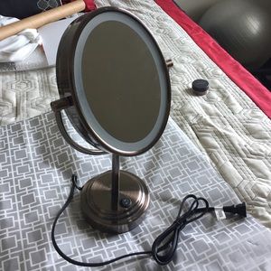 Free standing magnifying mirror with a light
