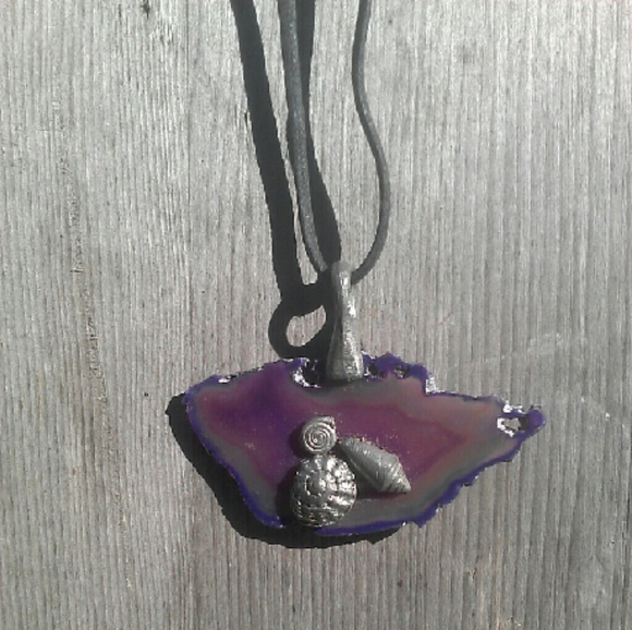 Pewter colored shells on a sliced purple stone.