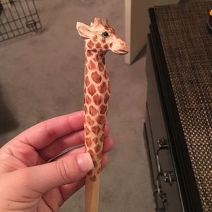Hang carved giraffe pen.