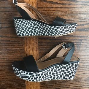 Stitched black and white wedge sandals.
