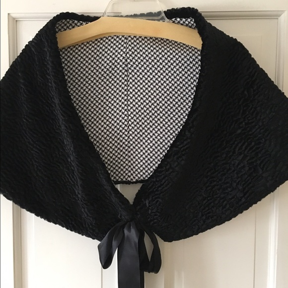 A soft short cape with a black ribbon tie
