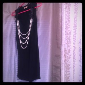 Cute pearl necklace attached to black tank