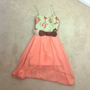 Hi-low dress in peach and floral with brown belt.