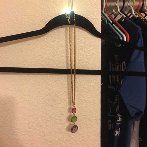 A chunky gold necklace with three jewels