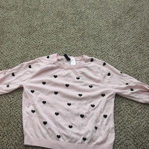A pink sweater with black hearts