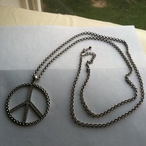 Big silver peace sign necklace.