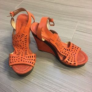 Orange wedge sandal with intricate cutout pattern