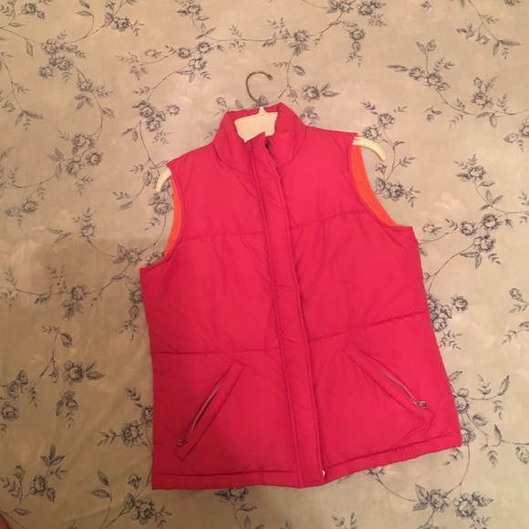 Pink puffer vest with a zipper and snaps.