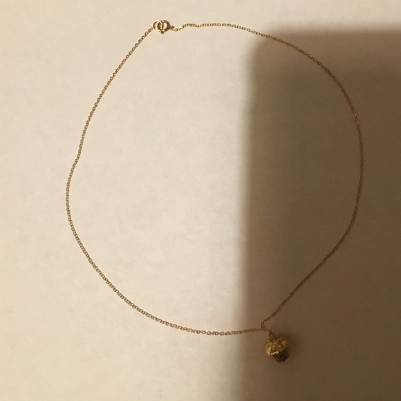 Gold colored necklace with cupcake shaped pendant.