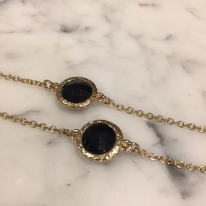 Long gold necklace with black gems