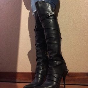 Over the knee pointed toe strappy black boots.