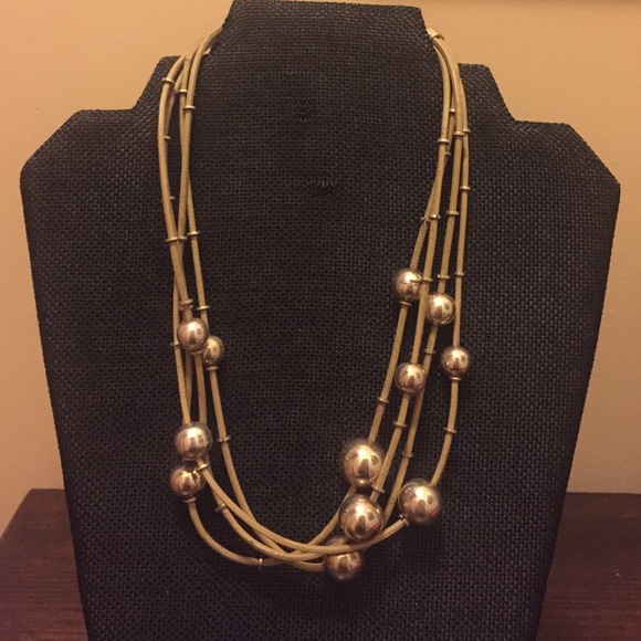 Silver balls on tan leather corded necklace.