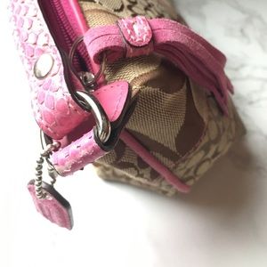 A pink and tan Coach mini hand bag.