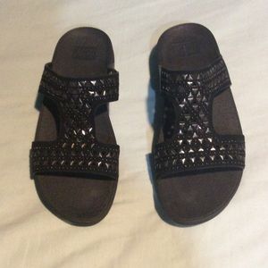 Black fitflops with embellishments.