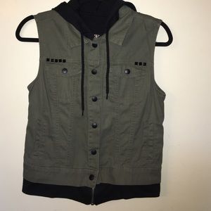 Army green vest with black hood attached .