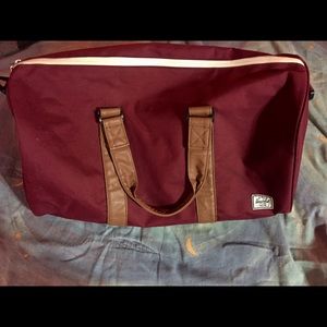 HERSCHEL SUPPLY CO. 
NOVEL WINE & TAN DUFFLE BAG