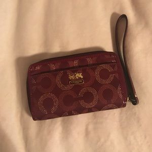 Maroon Coach wallet with wristlets carrying strap