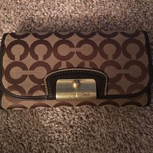 Brown coach wallet with check book cover.