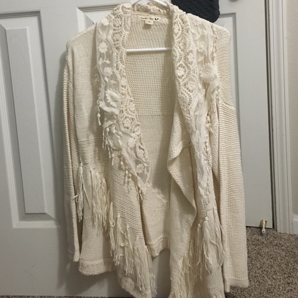 Off-white cardigan with lace and fringe.