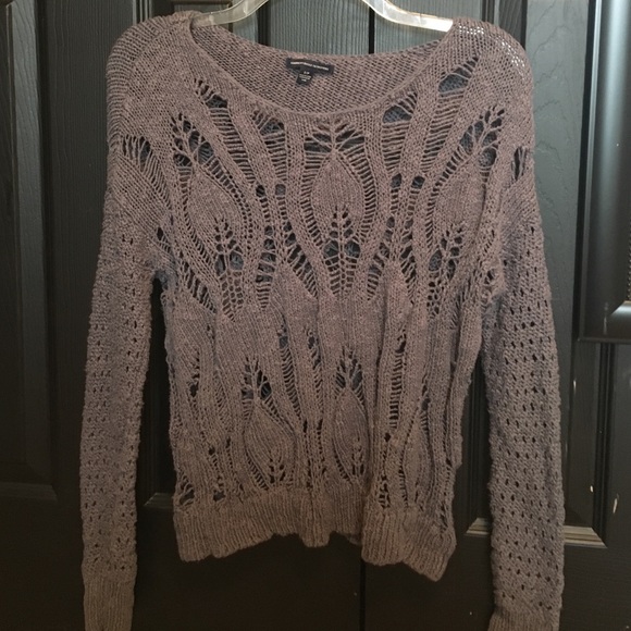 dark gray sweater with holes/detailing.