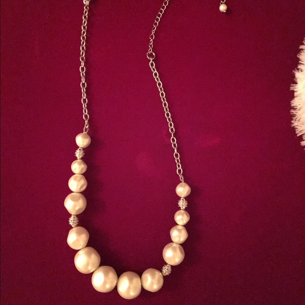 Pearl choker with shiny accents.