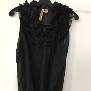 Shear sleeveless shirt with ruffle front bib.