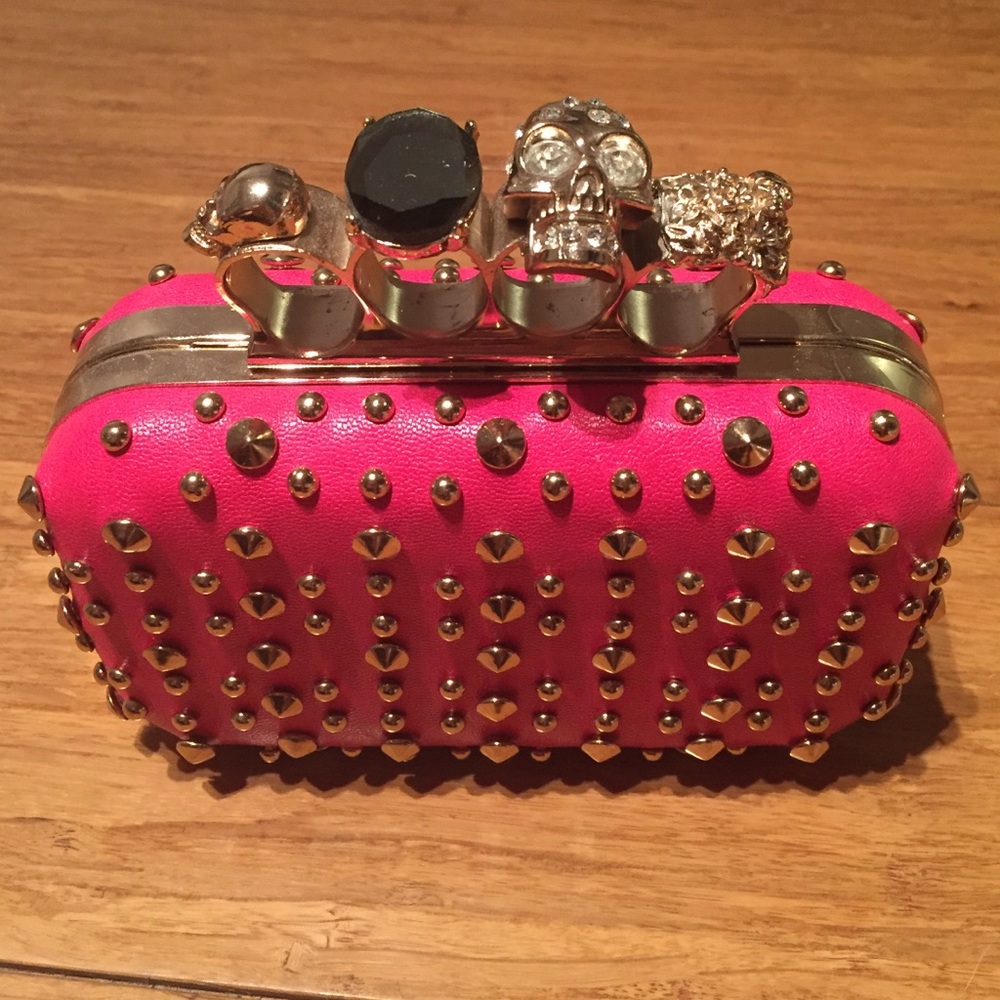 Skull hand purse pink with gold studs.
