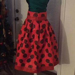 African print skirt with matching clutch bag.