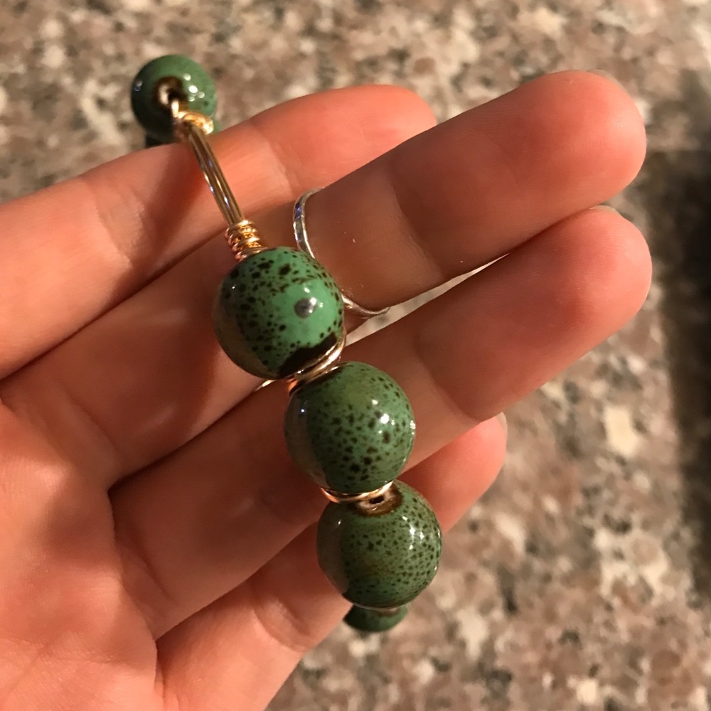 Gold woven bracelet with green ceramic beads
