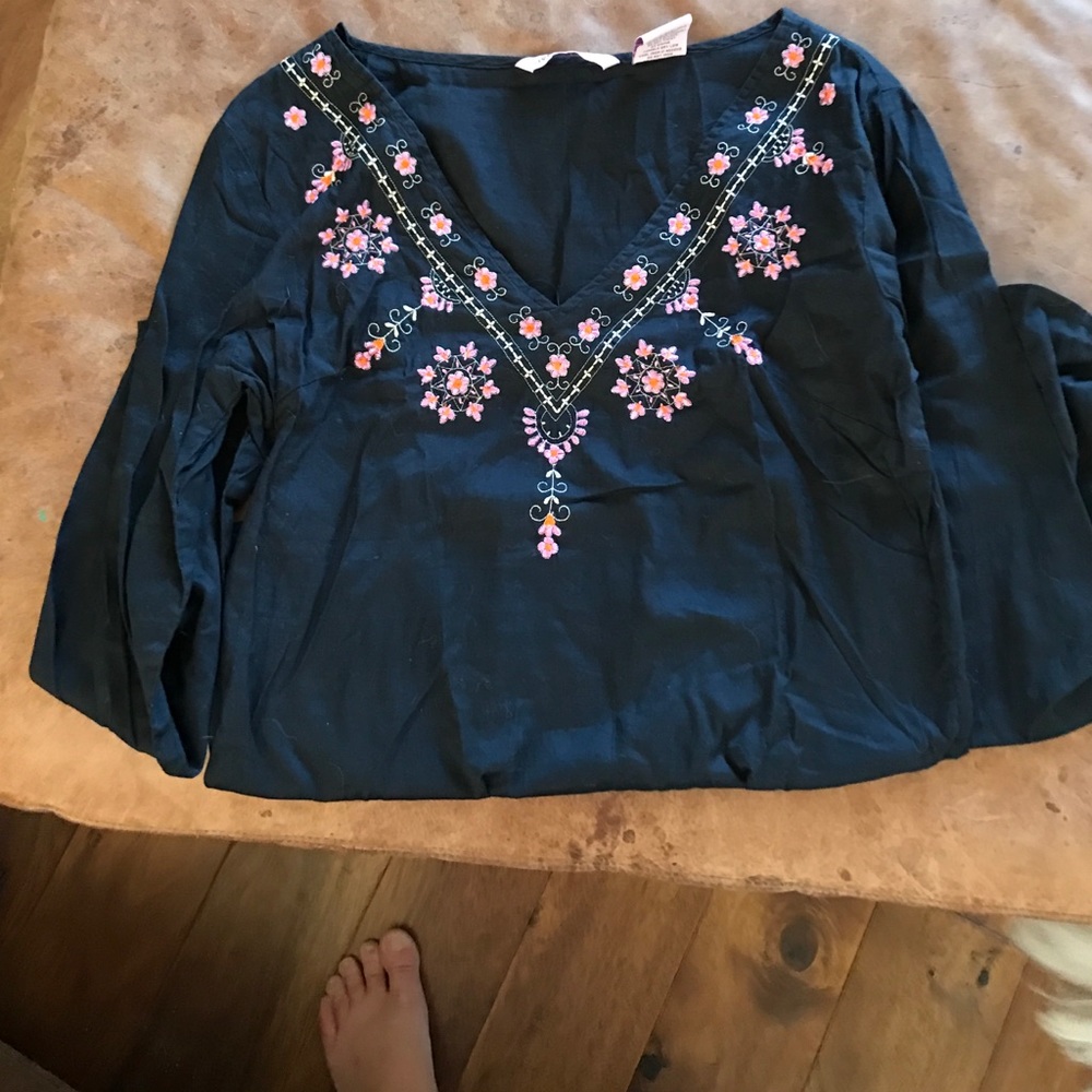 A SHIRT FOR SALE WITH EMBROIDERED FLOWERS ON IT