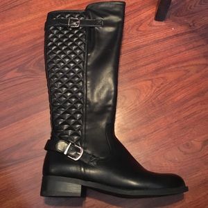Tall black riding style boots.