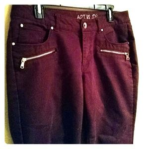 Maroon skinny jeans with gold zippers