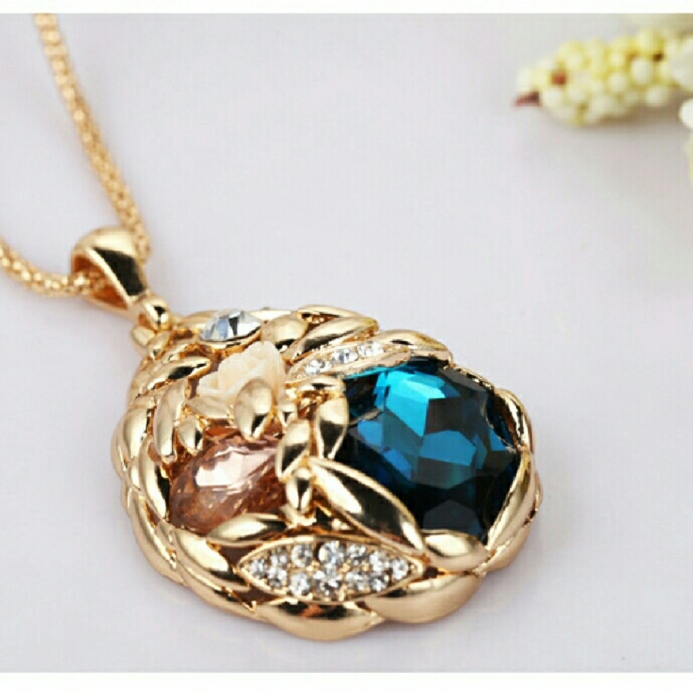 Gold flower pendant with popcorn chain. Blue stone