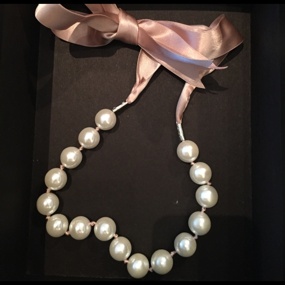 Large faux pearl necklace with pink ribbon detail