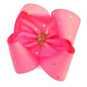 Boutique bow in coral with gold polka dots.