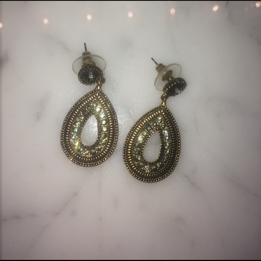 Gold earrings with emerald colored gems.