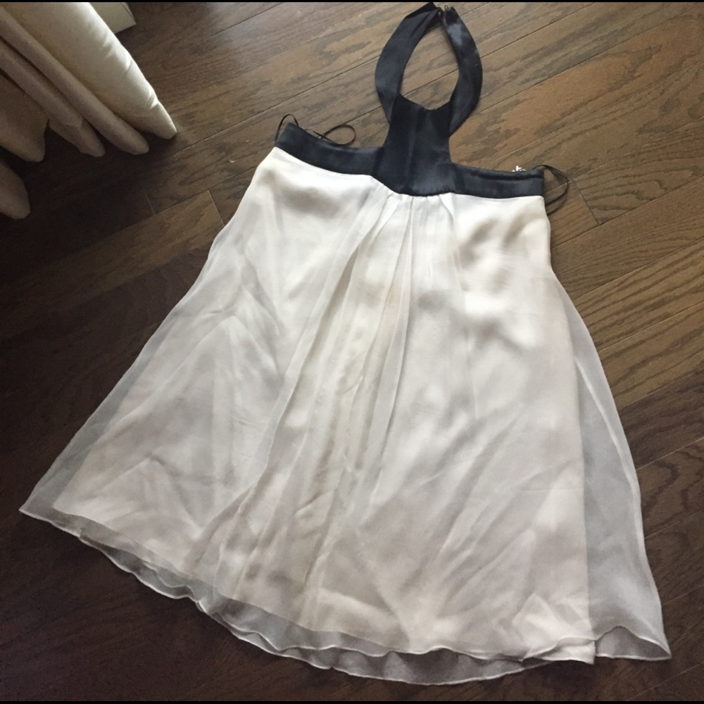 White shift dress with black halter snap collar.