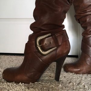 Brown leather boots with cute buckle accessory.