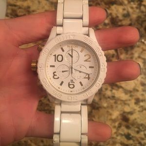 White and gold Nixon watch.