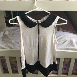 Beige top with black collar.