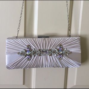 Light purple clutch with removable shoulder strap.