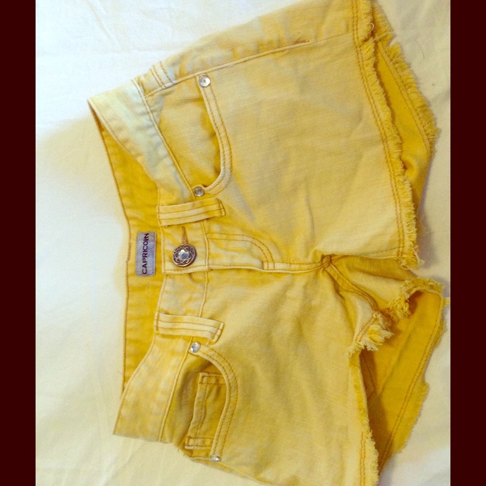 Yellow shorts frayed at bottom from buckle
