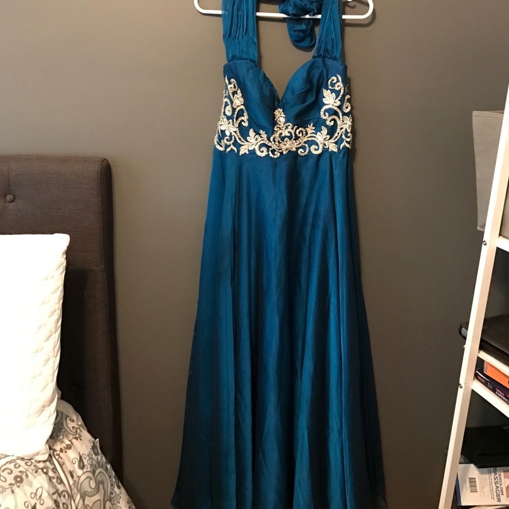 A line halter style teal gown. Rhinestone accent