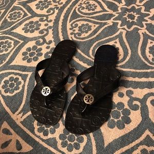 Black patent leather Tory Burch flip-flops.