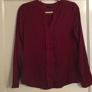 Deep red-wine colored blouse.