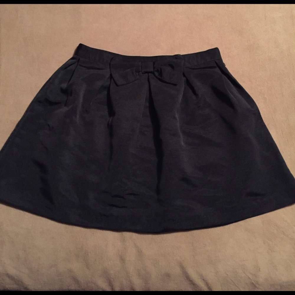 Black skirt with bow in front. Zipper on side. M.