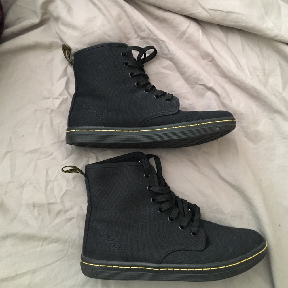 Black high top dr. marten shoes.