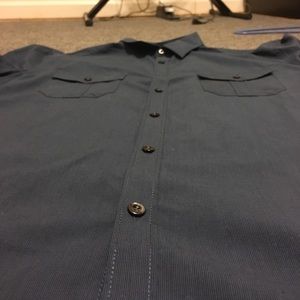 A navy blue button down, can roll at the sleeves