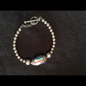 Sterling bracelet with multi-color gems inlaid.
