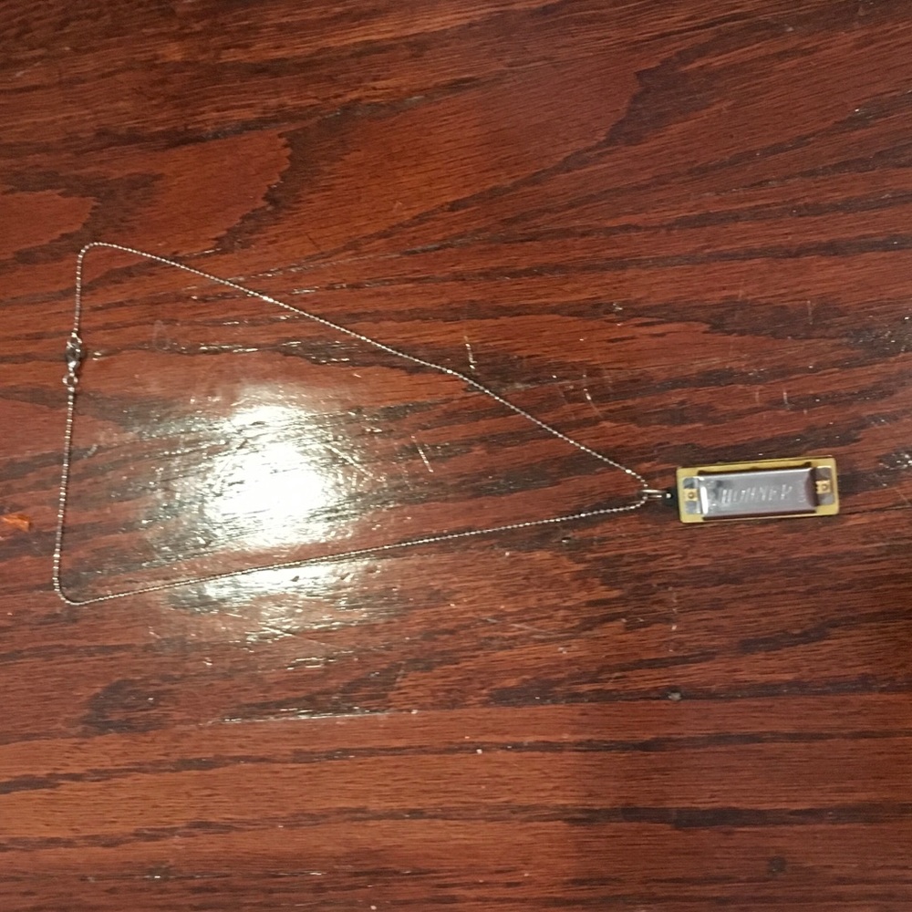 A harmonica with a silver necklace